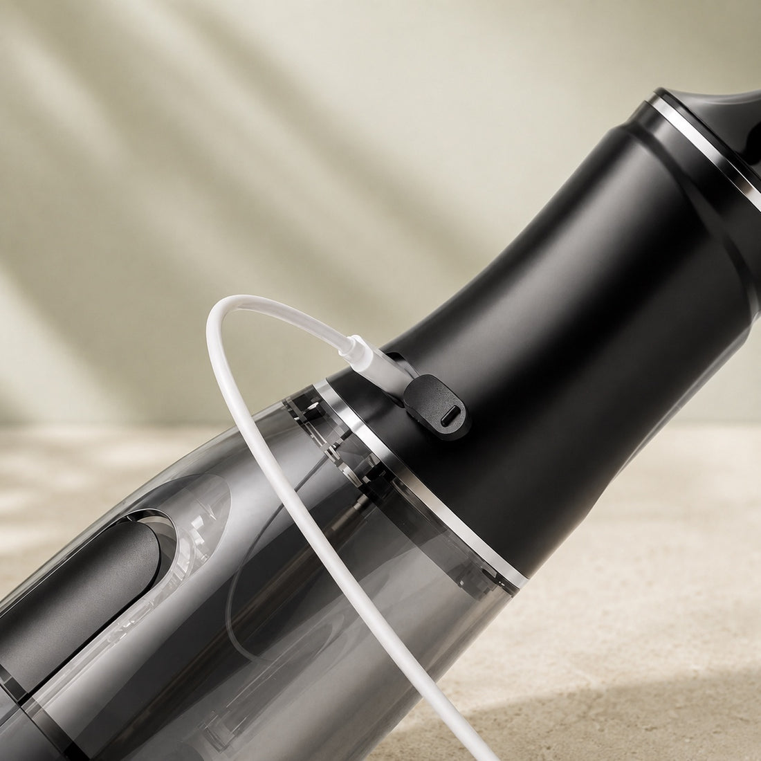 Gros plan sur le câble USB-C branché à l’hydropulseur AquaPulse One Noir Minuit, avec cache du port ouvert.